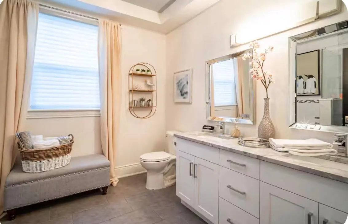 Clean bathroom in a rental home with folded white towels on the vanity