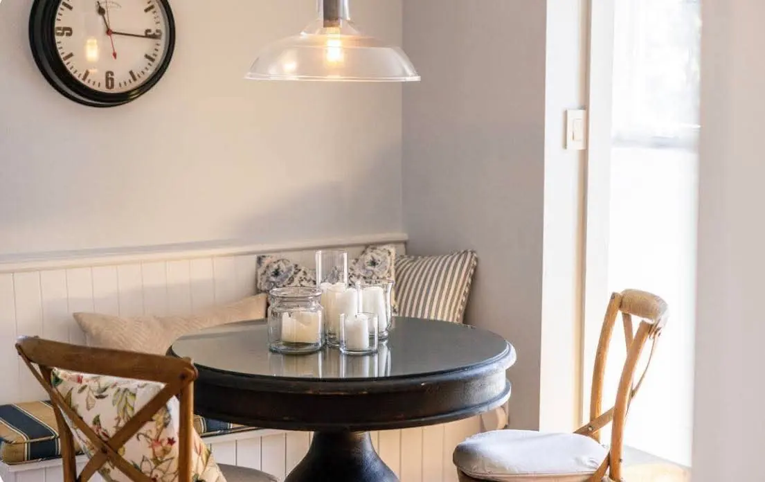 Round dining table and window seat in a bright corner of a rental home