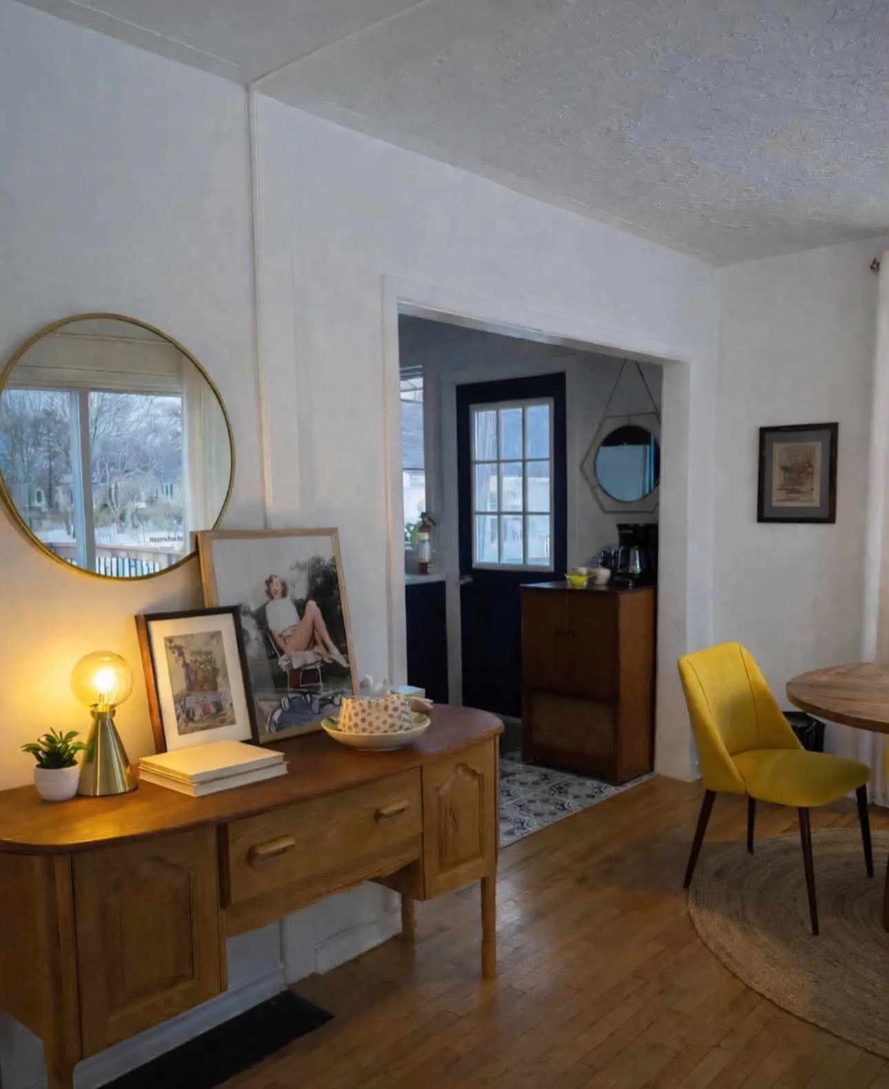 Living area of a rental home with wooden furniture, a sideboard and a yellow chair